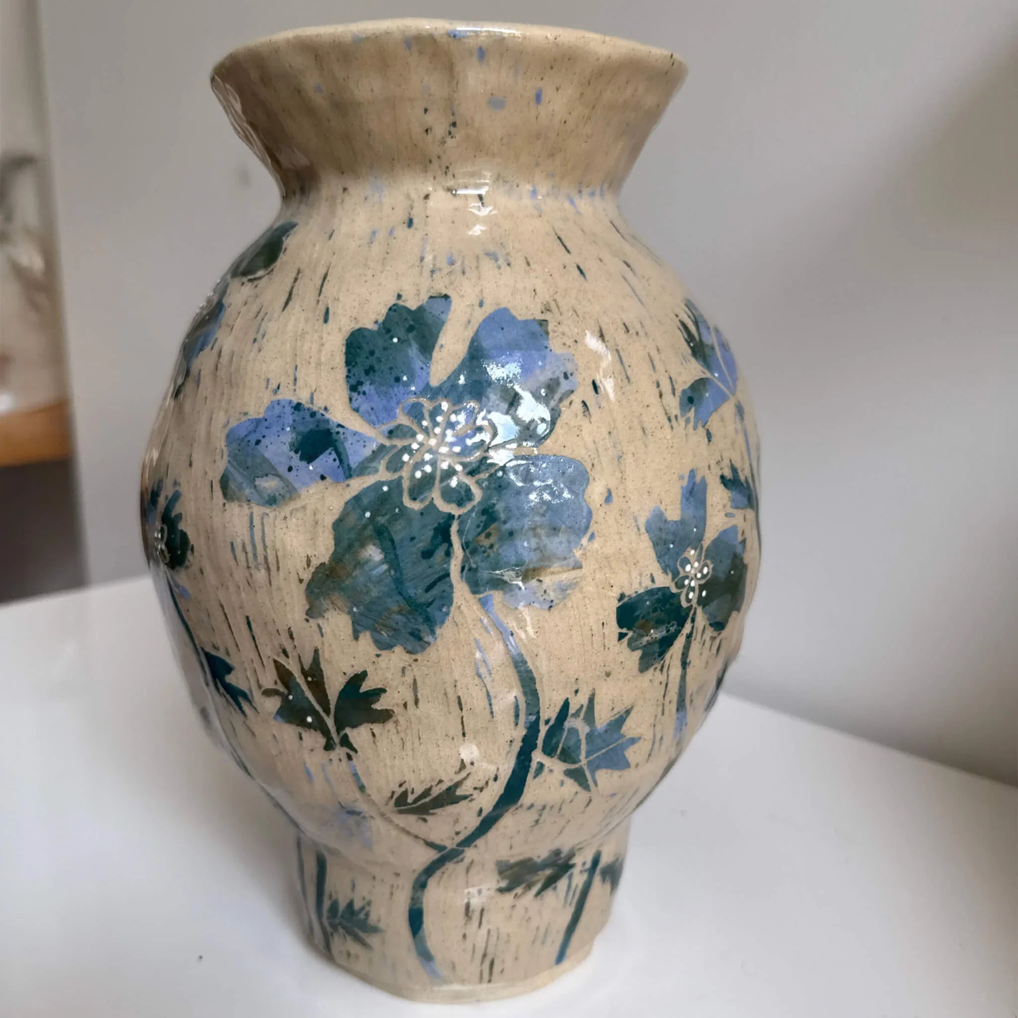 Ceramic vase with blue floral patterns on a white surface