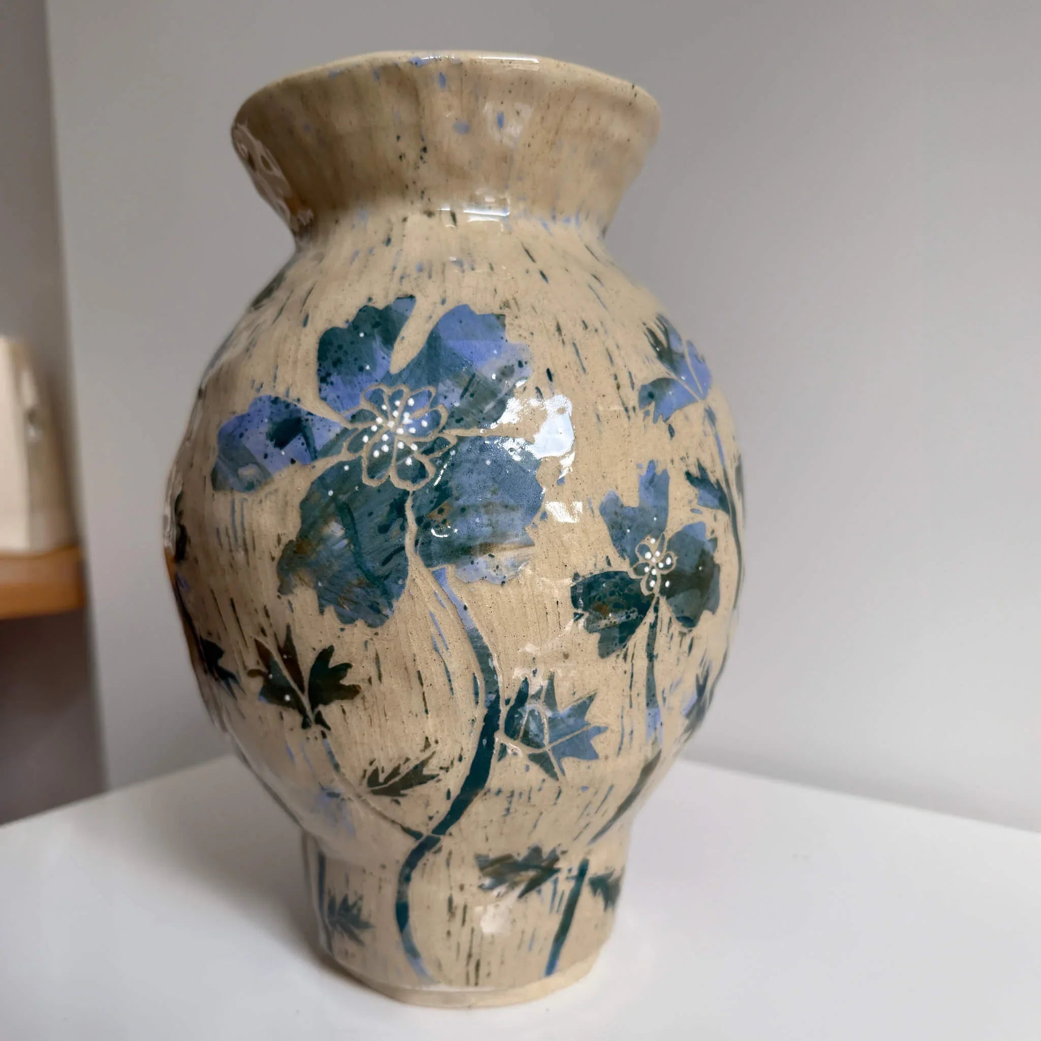 Ceramic vase with blue floral design on a plain background